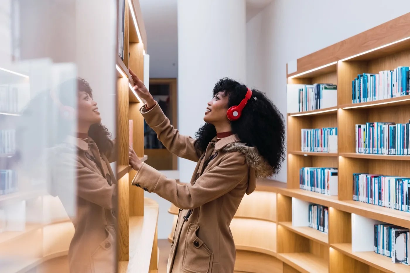 Kütüphane rafından kitap seçen bir okuyucu